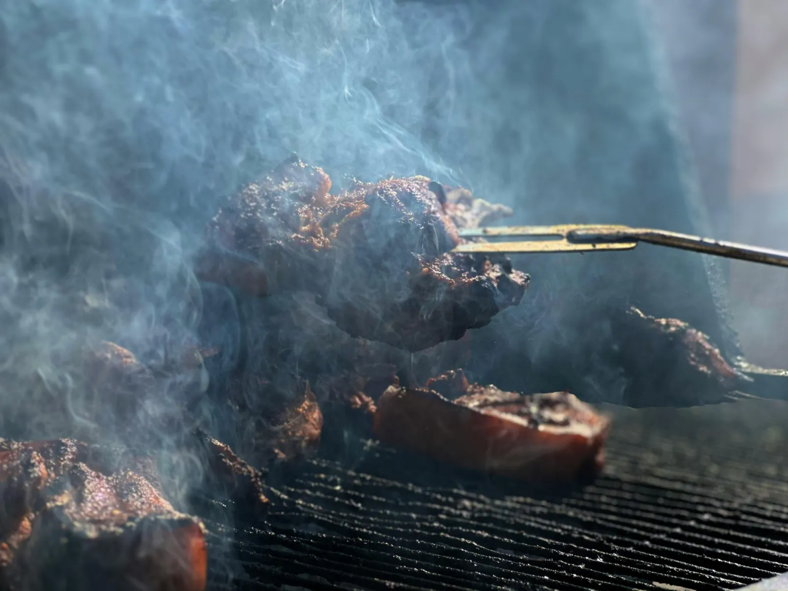 Cortes premium na brasa com fumaça e finalização ao vivo